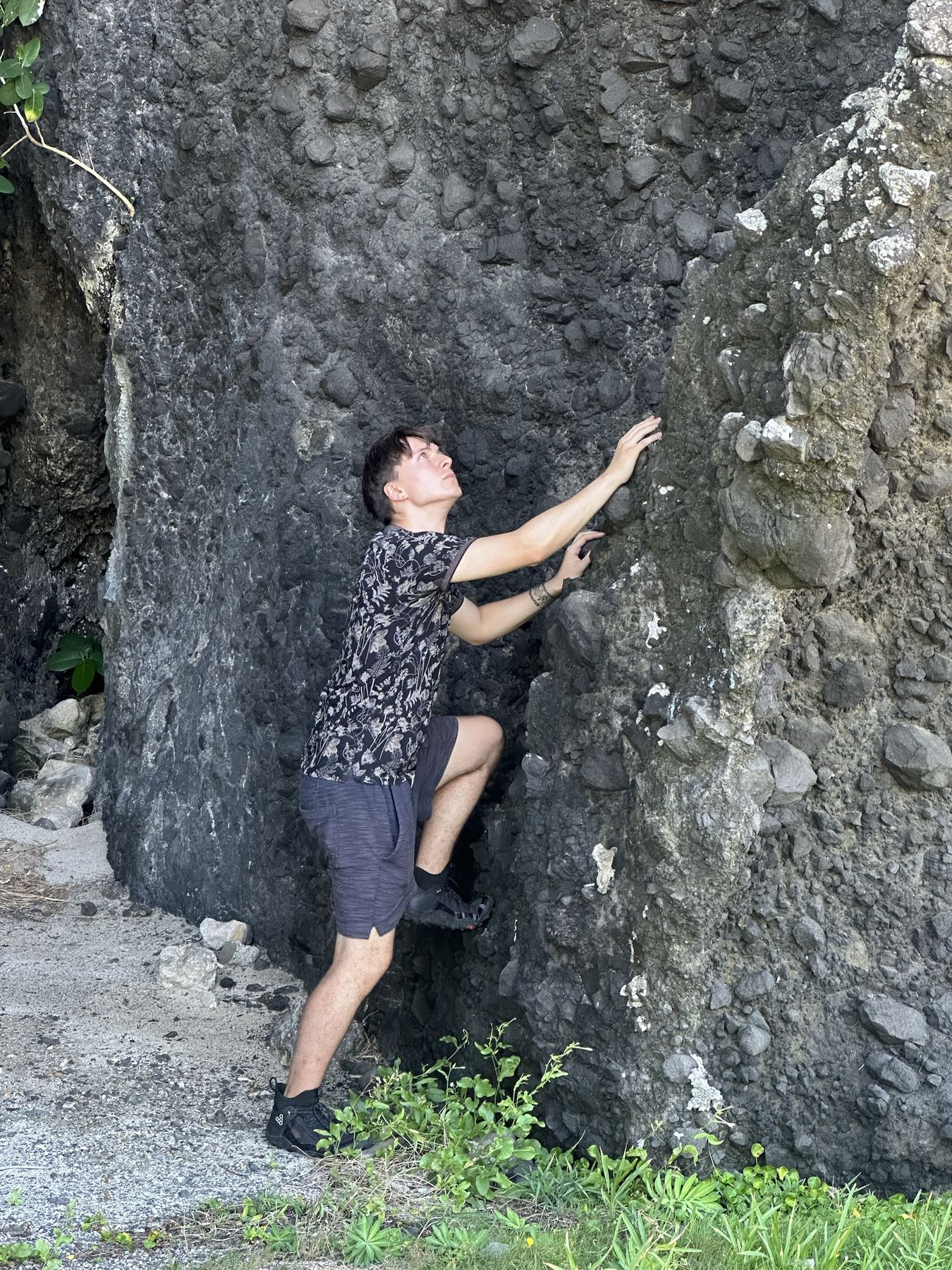 Maciej climbing a dark volcanic rock face